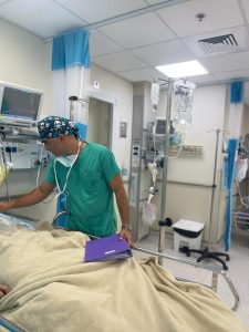 A photo of Tamer Hidari tending to a patient at the Nazareth Hospital.